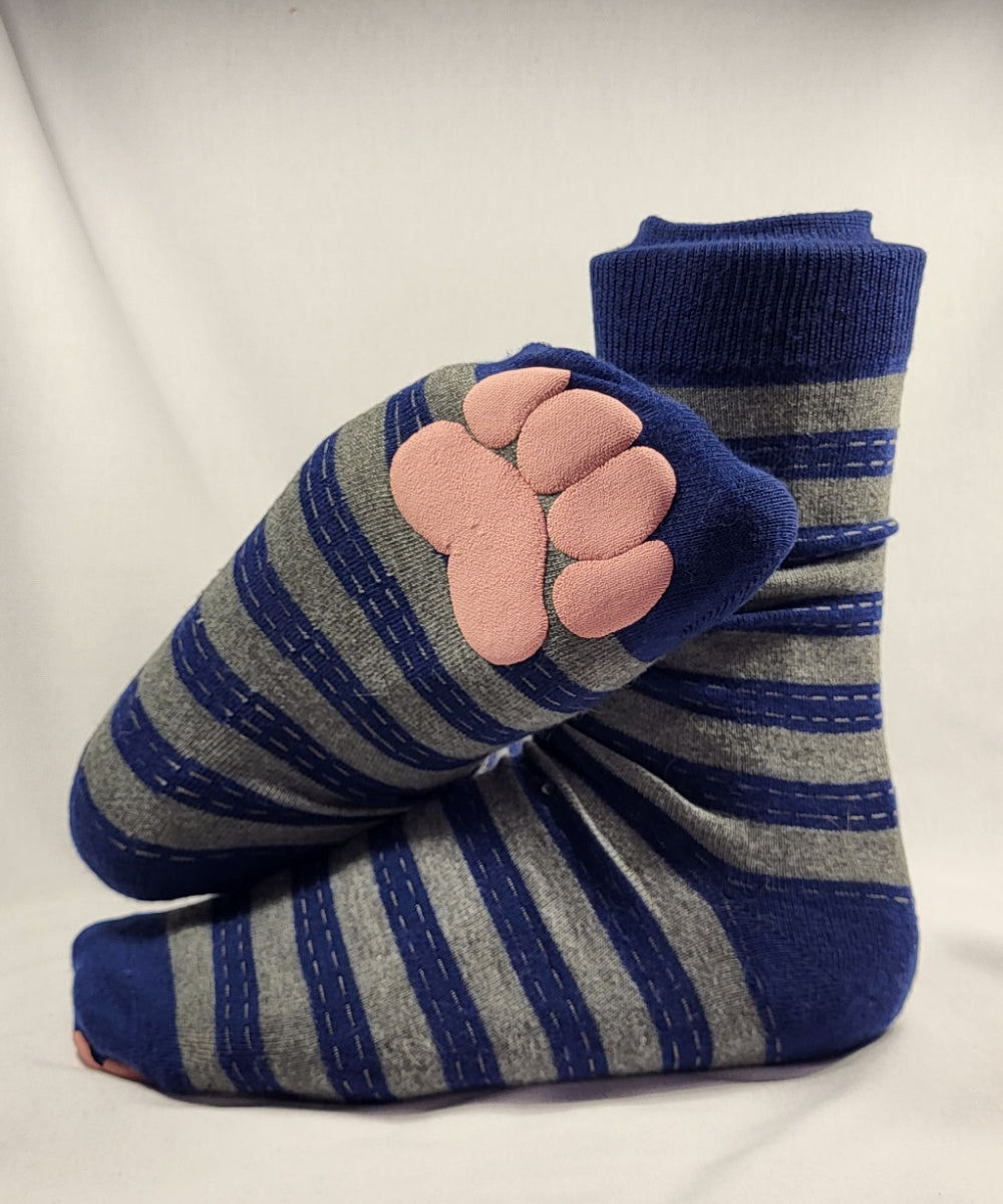 Pair of blue and gray striped socks with pink paw print on a white background
