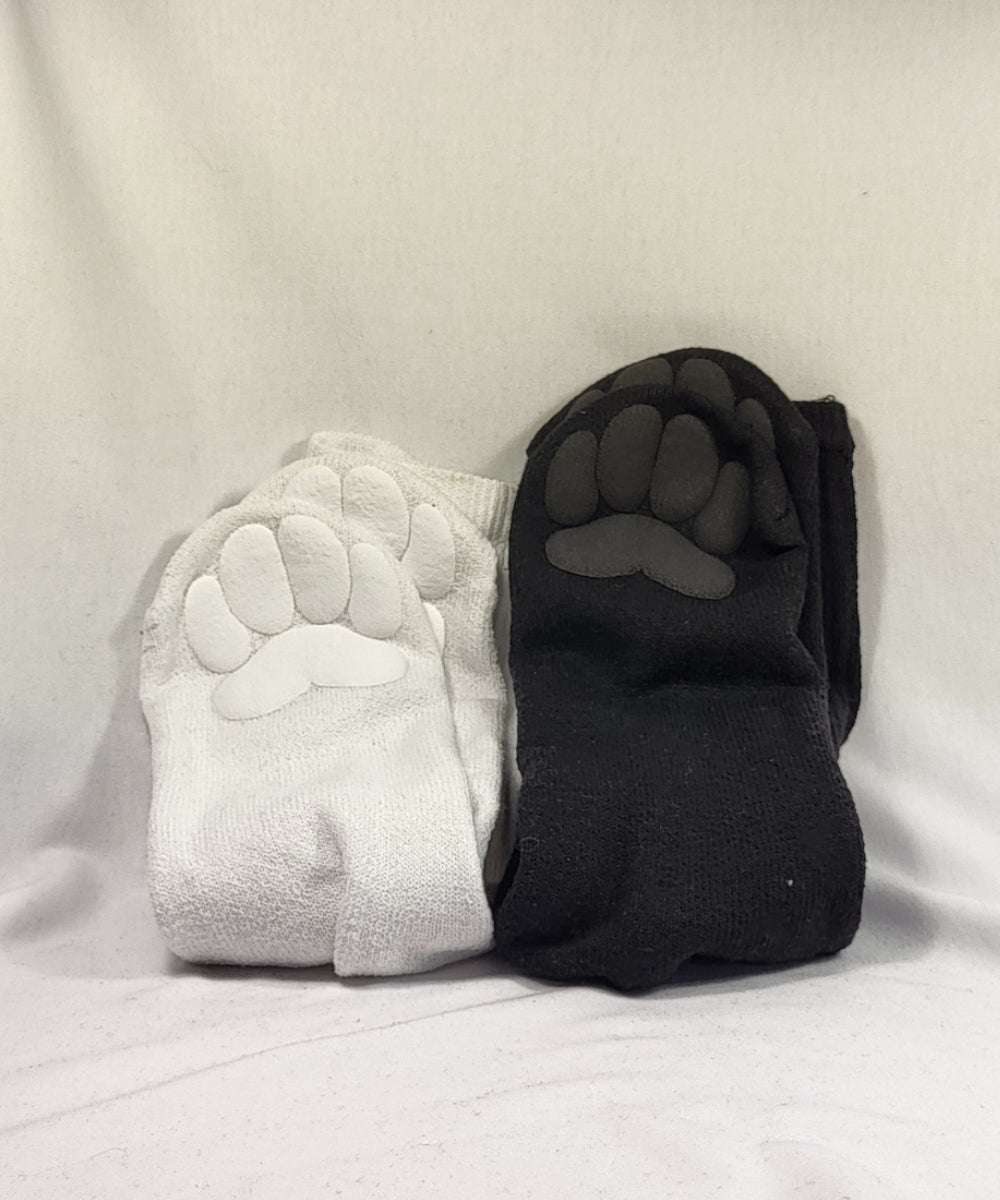 Pair of white and black socks with paw print design on a light gray background